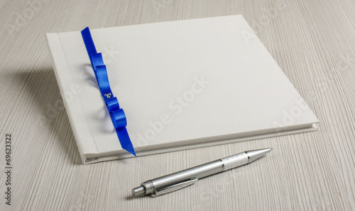 Photos Guestbook and pen on the grey wood table