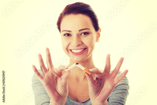 Young beautiful woman holding broken cigarette.