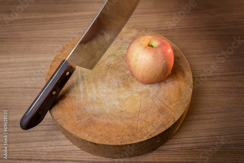 Red apple and Knife on wooden cutting board