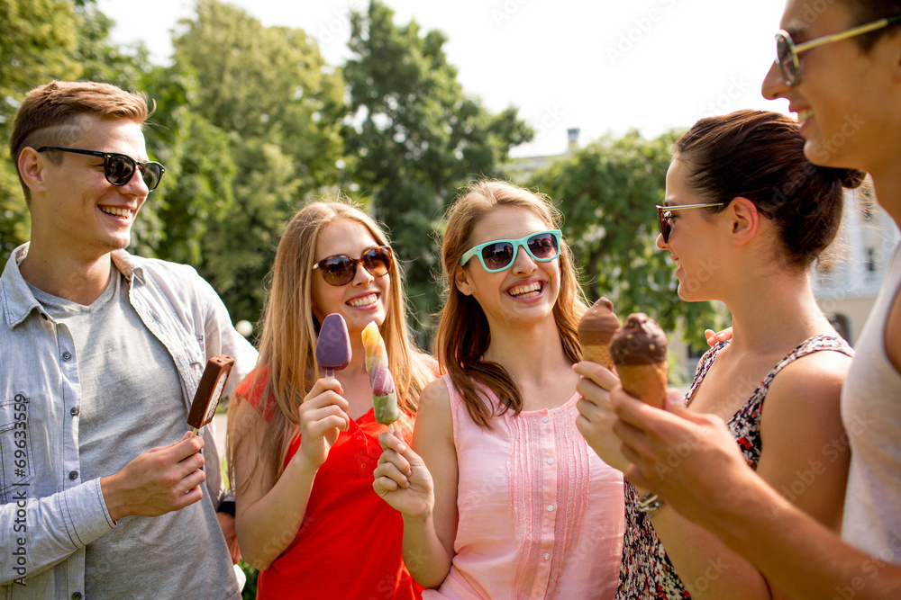 Obraz premium group of smiling friends with ice cream outdoors