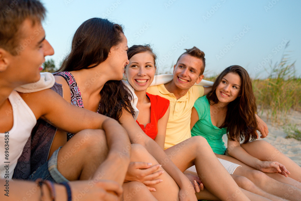 Fototapeta premium smiling friends in sunglasses on summer beach