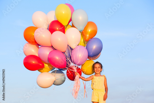 Happy little girl child kid with balloons on sky background