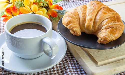 Some croissants, bread and coffeeon dish