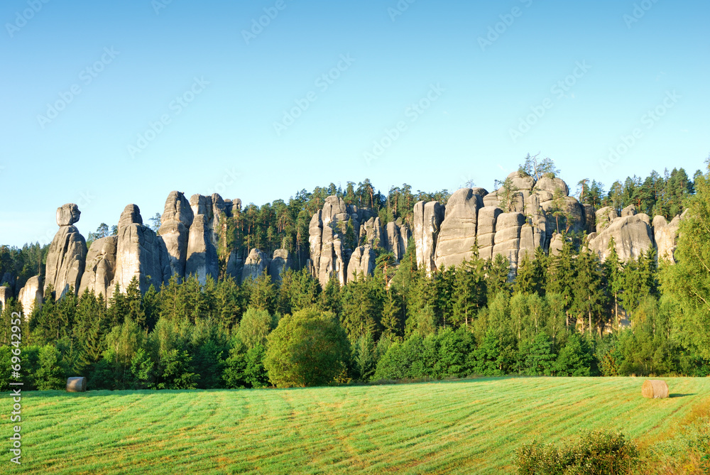 High sandstone towers rising from a forest in Adrspach
