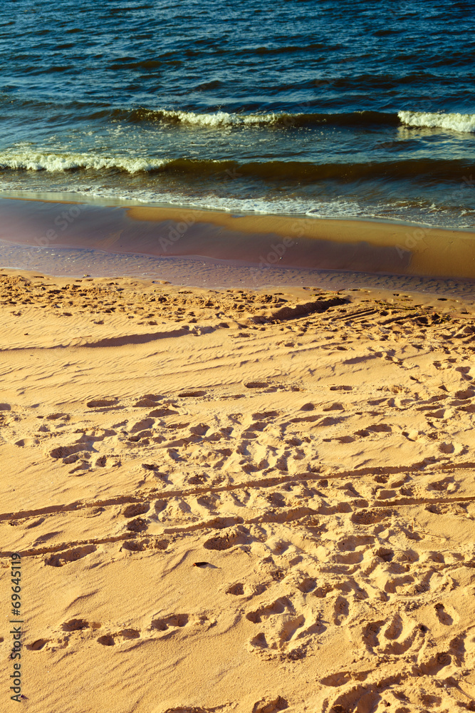 Closeup of water waves at sandy beach. Sea or ocean.