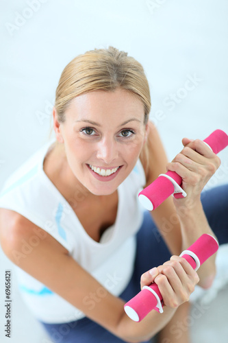 Upper view of fitness girl holding dumbbells