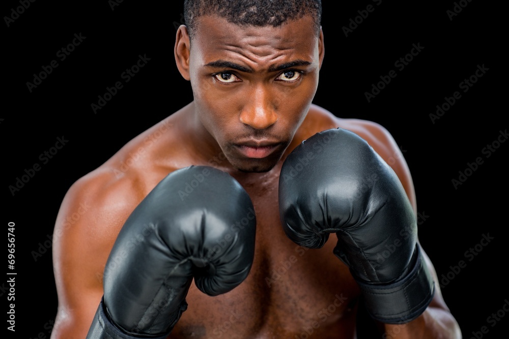 Portrait of shirtless muscular boxer in defensive stance