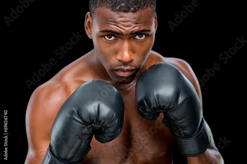 Portrait of shirtless muscular boxer in defensive stance © WavebreakMediaMicro