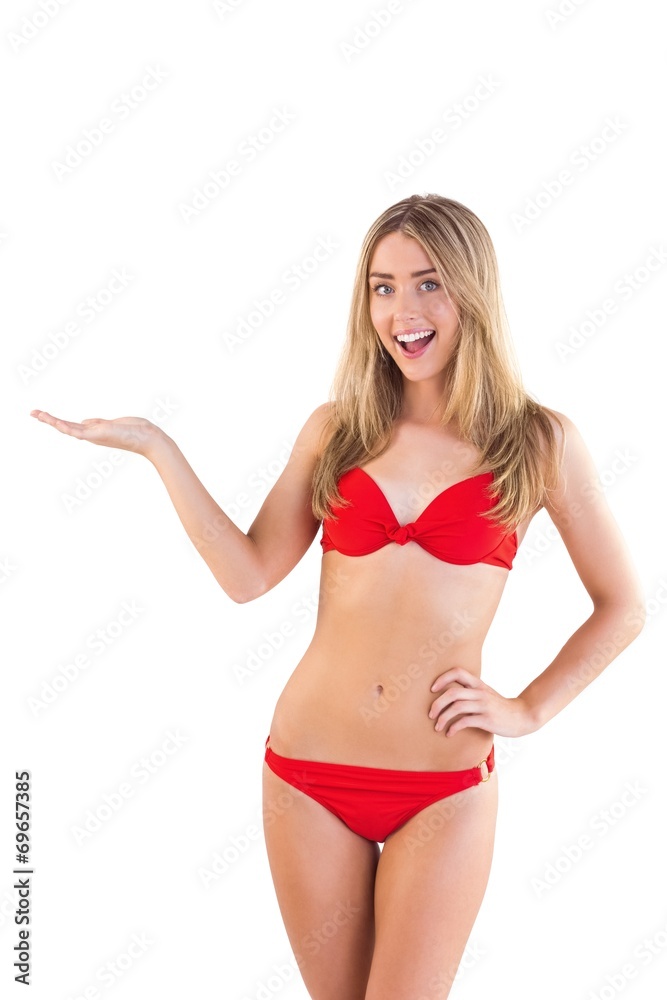 Fit blonde in red bikini presenting with hand Fit blonde in red bikini presenting with hand