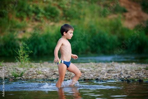 Boy walking on the water along the shore