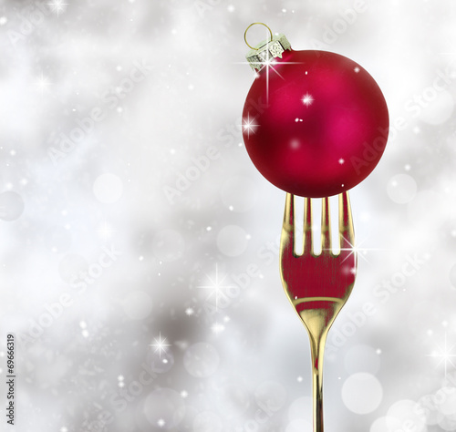 Golden fork with Christmas ball in a glittery background