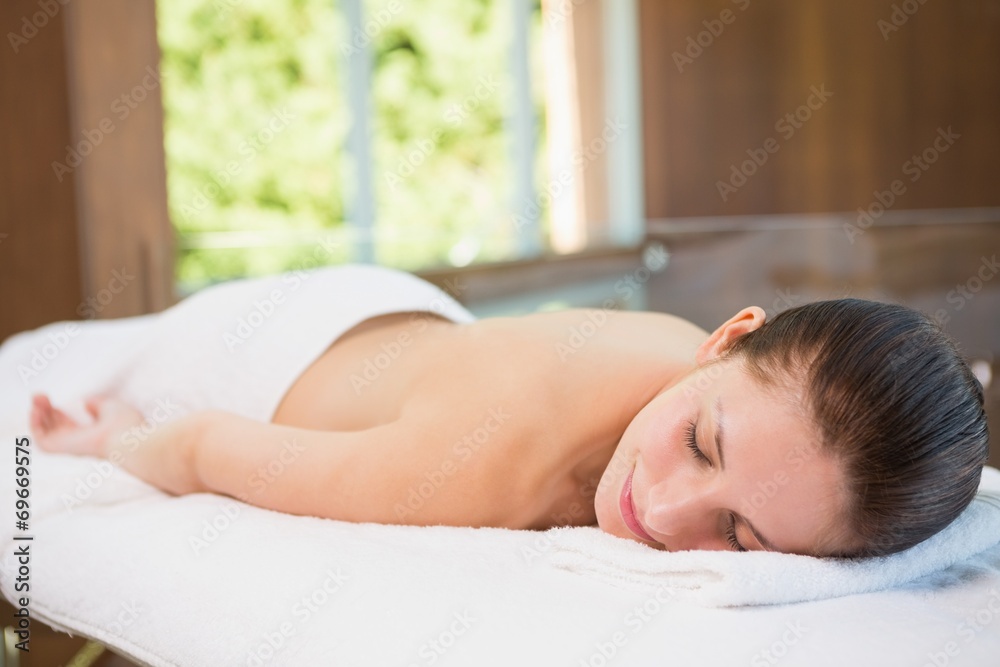Beautiful woman lying on massage table at spa center Beautiful woman lying on massage table at spa center