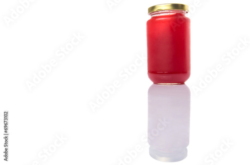 A bottle of strawberry jam over white background 