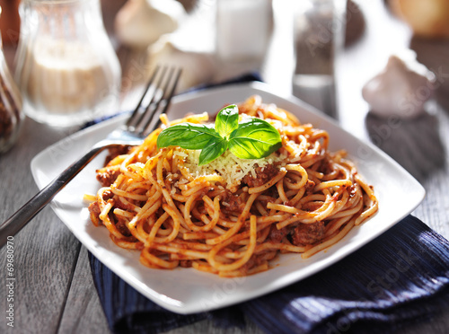 spaghetti in bolognese sauce with basil garnish photo