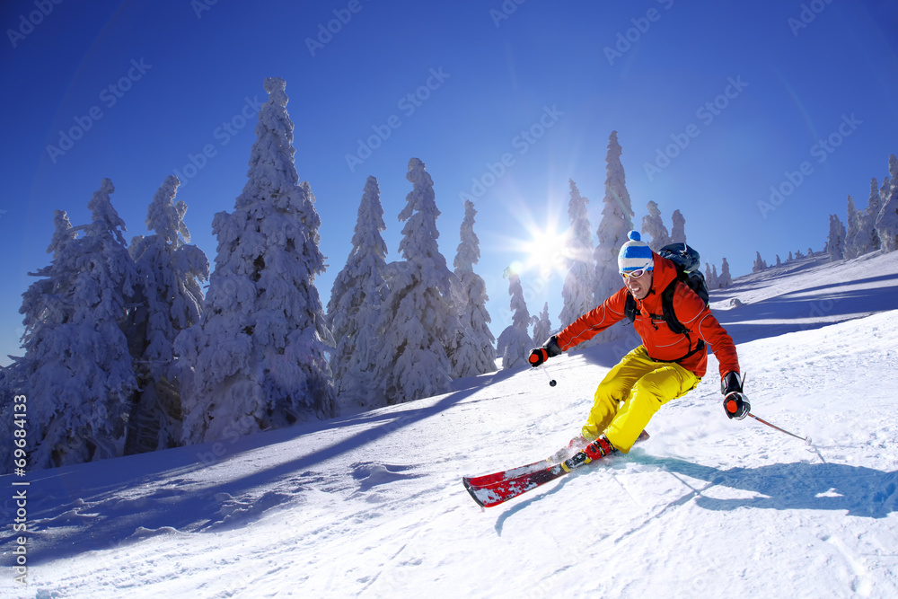 Skier skiing downhill in high mountains against sunset - obrazy, fototapety, plakaty 