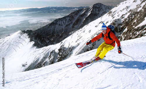 Skier skiing downhill in high mountains 