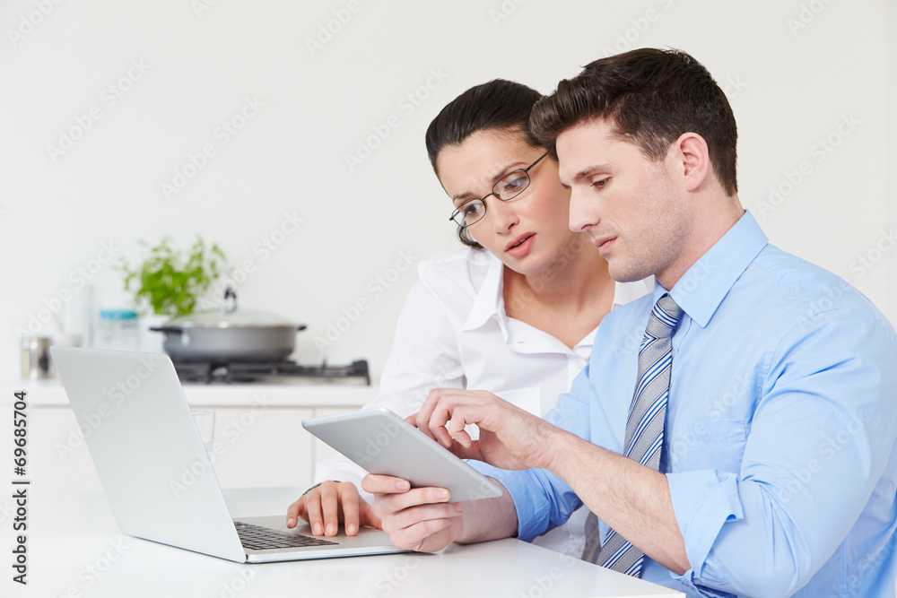 Couple Using Laptop And Digital Tablet At Home Couple Using Laptop And Digital Tablet At Home