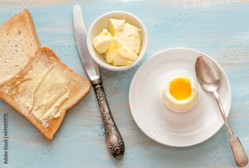 Boiled egg with crispy toasts on the wooden table