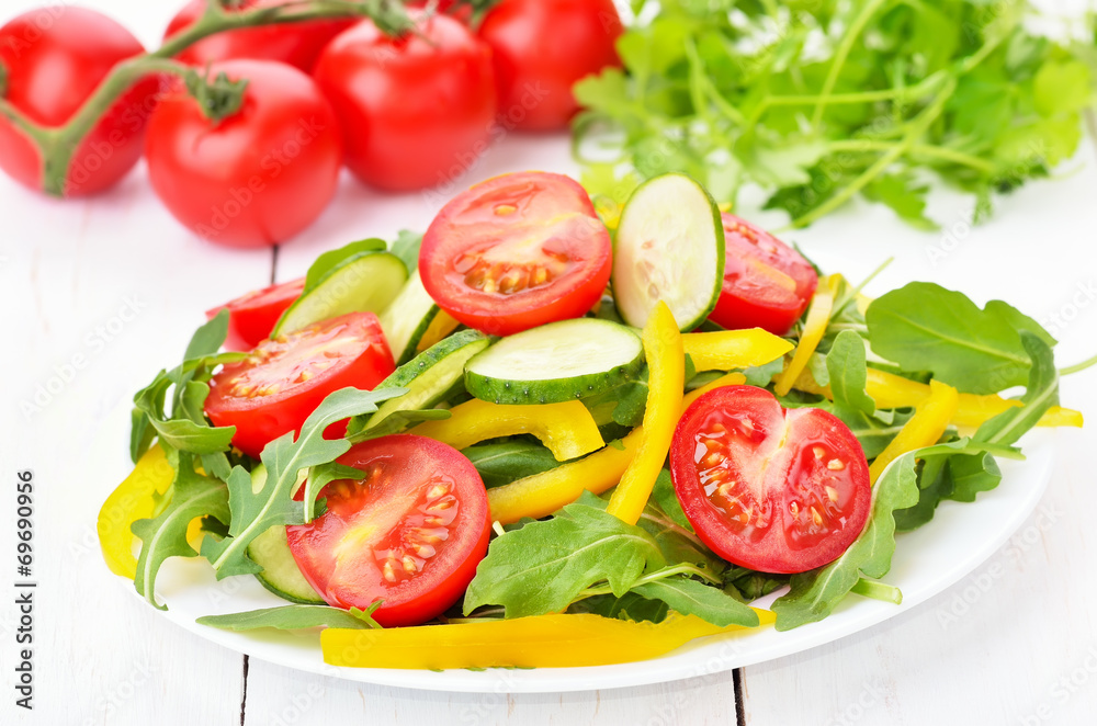 Vegetable salad with tomatoes, cucumbers, bell peppers and rucol
