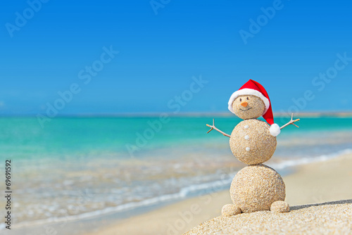 Sandy snowman in santa hat. Holiday concept