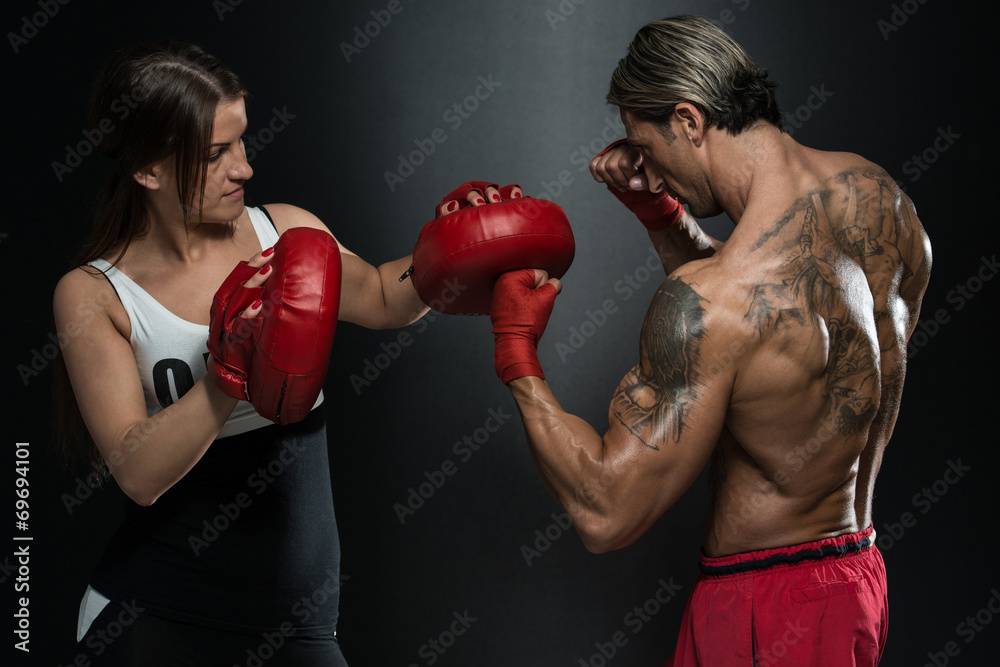 Fit Woman And Her Trainer Boxing Indoors