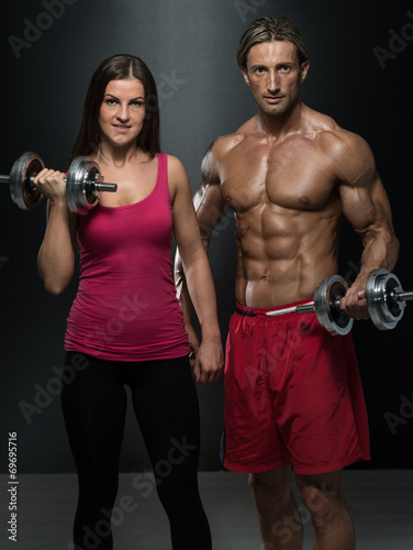 Athletic Man And Woman With A Dumbells