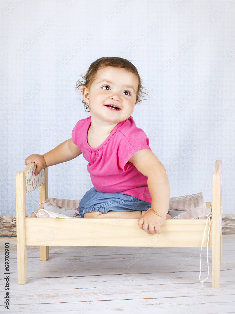 Little baby girl sitting on the small bed Little baby girl sitting on the small bed