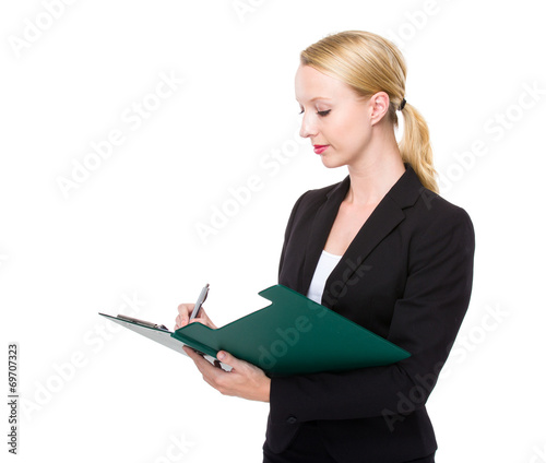 Caucasian businesswoman write on clipboard