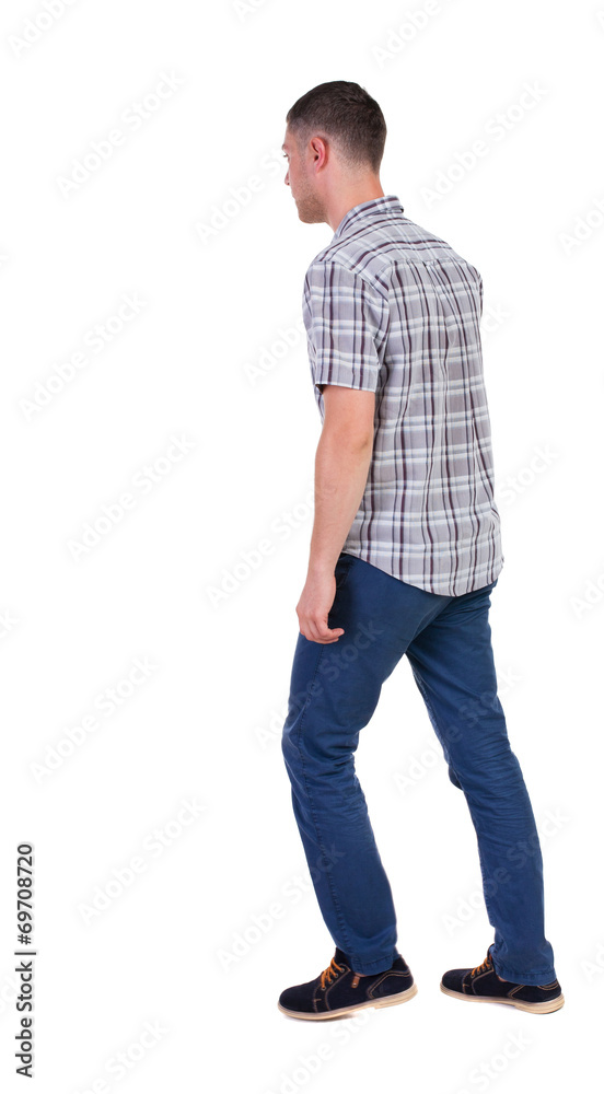 Back view of going handsome man in jeans and a shirt. Back view of going handsome man in jeans and a shirt.