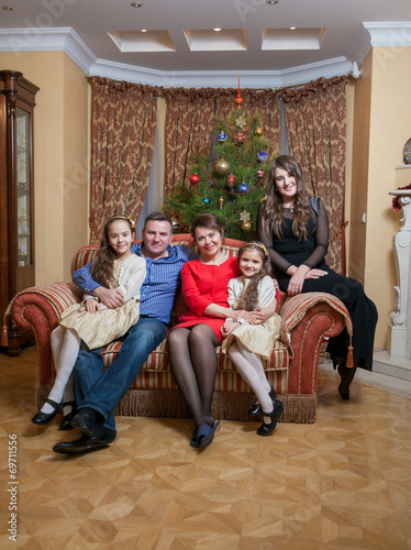 happy family sitting on sofa at living room at christmas eve