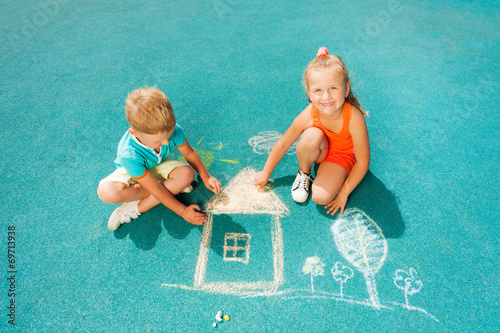 Boy and girl draw chalk image sitting toggether photo