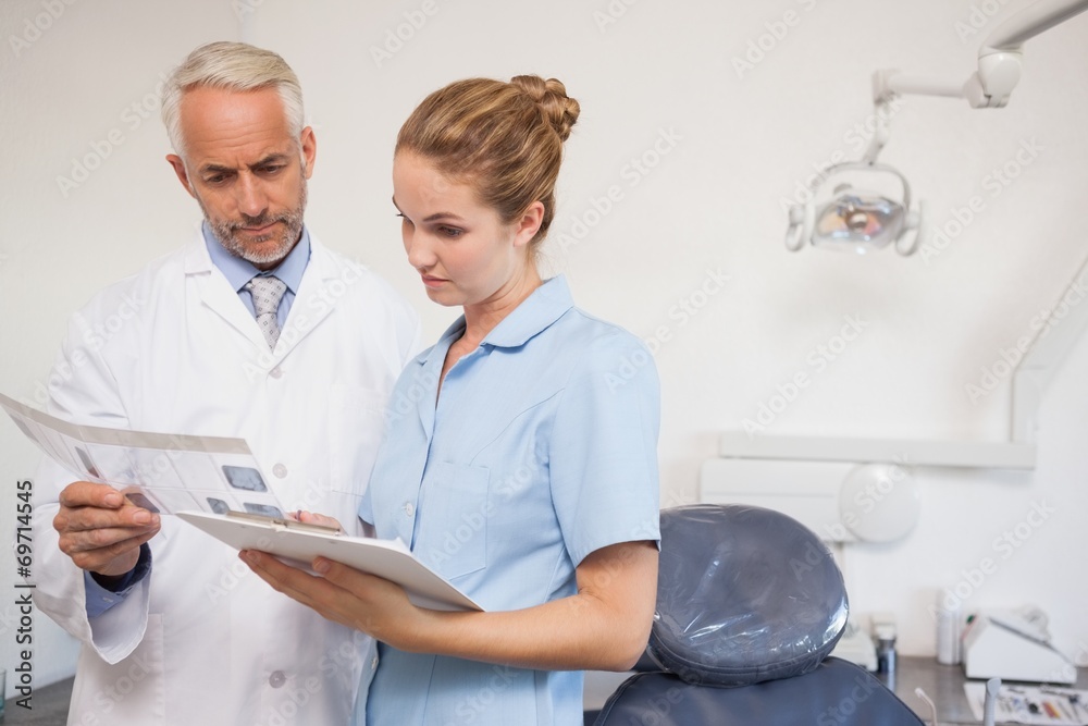 Dentist and assistant studying x-rays