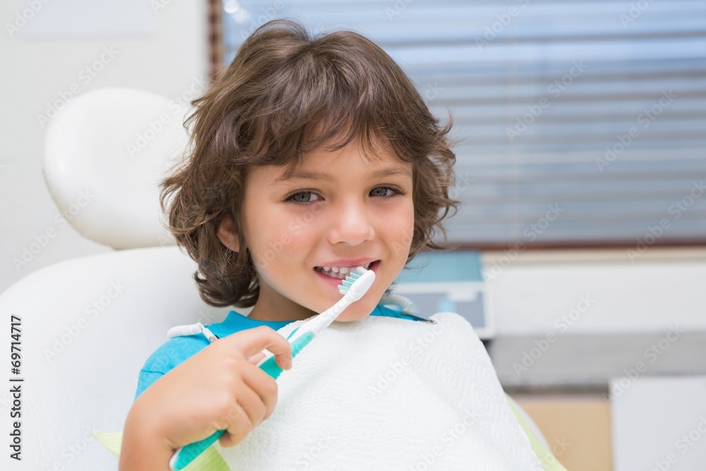 Little boy in dentists chair using toothrbrush Little boy in dentists chair using toothrbrush