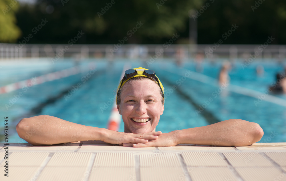 One smiling woman by the swimming pool