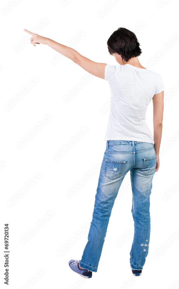 Back view of young brunette woman pointing at wall. beautiful gi Back view of young brunette woman pointing at wall. beautiful gi