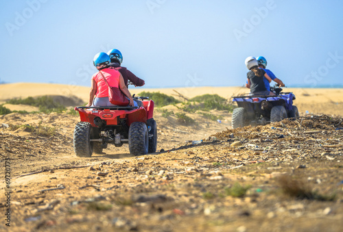 Fotografia Two teams racing on quads towards the sea