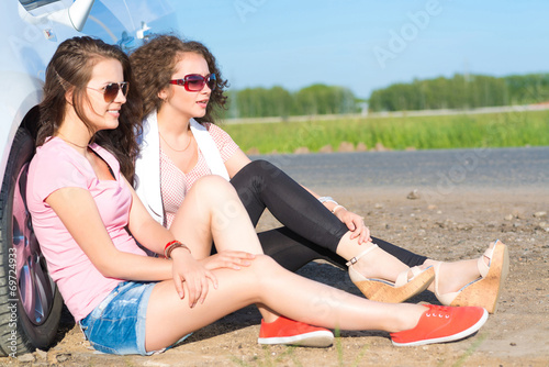 Two attractive young women wearing sunglasses