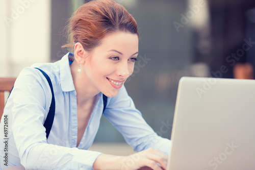 Happy woman working on computer laptop browsing internet