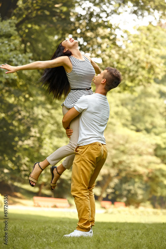 Happy couple has a fun in summer park