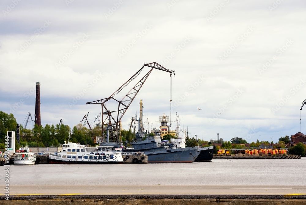 Fototapeta premium War ship and tug boat in port near crane