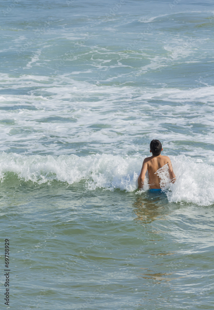 Niño bañandose en el mar