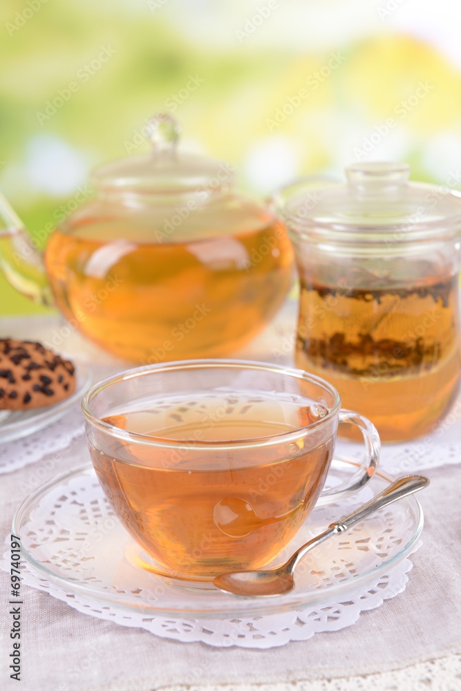 Teapot and cups of tea on table on bright background Teapot and cups of tea on table on bright background