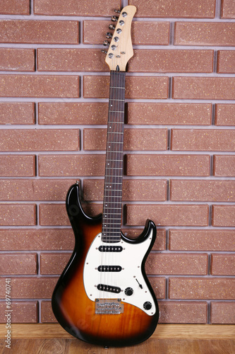 Guitar on brick wall background © Africa Studio
