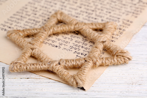 Star of David and page of Genesis book on wooden background