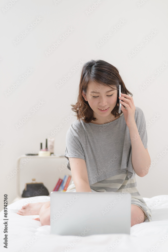 ベッドで電話する女性 ベッドで電話する女性