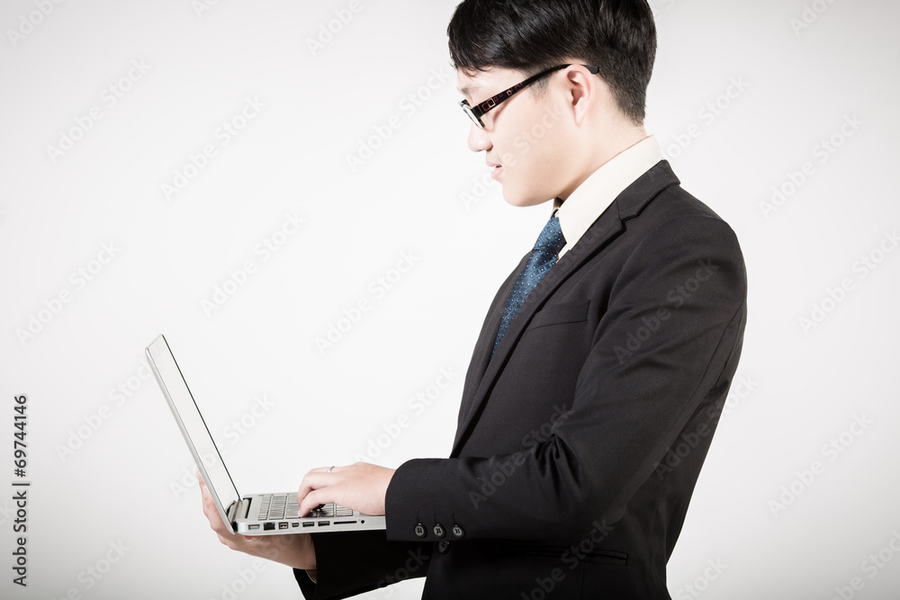 Asian business man using laptop computer isolated on white backg Asian business man using laptop computer isolated on white backg