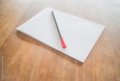 Billede på lærred White paper and red pen on wooden table