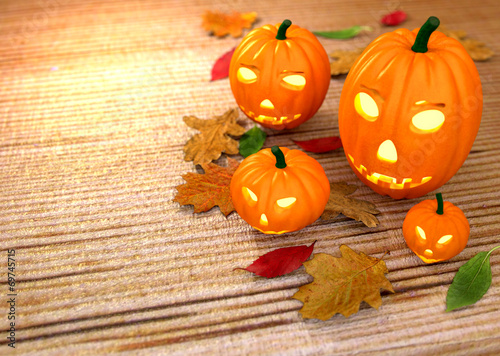 Halloween pumpkins, wooden background with dry leaves