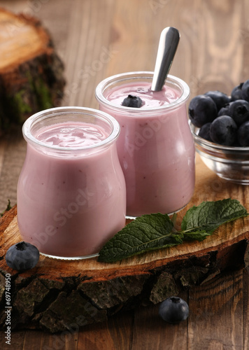 yogurt with blueberries in a glass jar and blueberries in a glas