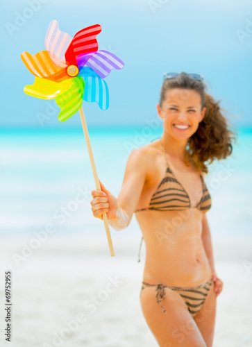 Closeup on happy young woman holding colorful windmill toy